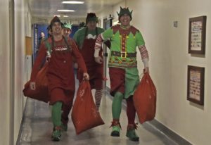 Heading down the hall to see the kids; the elves of 400 Tactical Helicopter Squadron – including (from left) Aviator William Rittershofer, Corporal Martin Hamel and Corporal Jesse MacIlroy – are ready to bring some holiday cheer to children at the hospital. PHOTO: © Steve Bigg, Locked On Photography