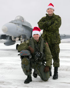 Captain Sébastien Tremblay-Verreault (kneeling) from 425 Tactical Fighter Squadron at 3 Wing Bagotville, Quebec, is one of the pilots who will escort Santa over North America in 2016. Master Corporal Scott Rose is his crew chief. PHOTO: Corporal Jean Roch Chabot,