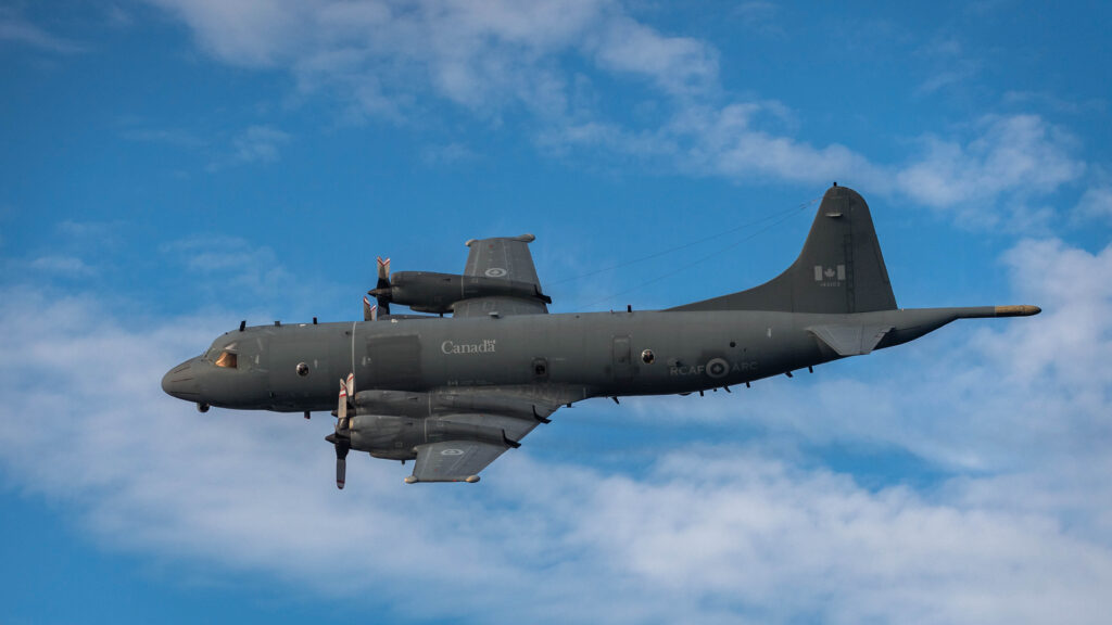 A CP-140 Aurora aircraft flies over HMCS GLACE BAY during Operation NANOOK 2020 on August 21, 2020. Photo by Corporal David Veldman, Canadian Armed Forces Photo 20200821NKAD0266D010