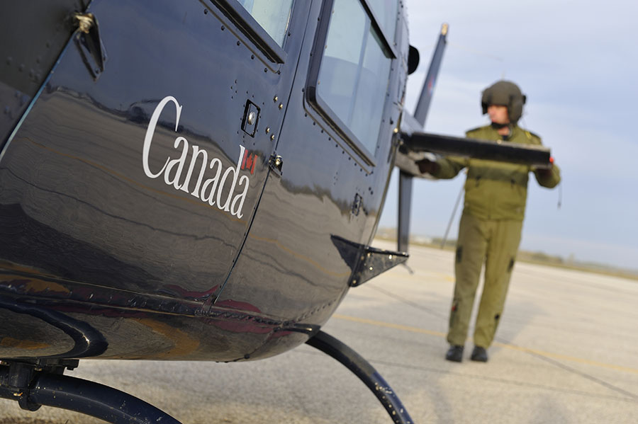 An aircrew man beside a helicopter.