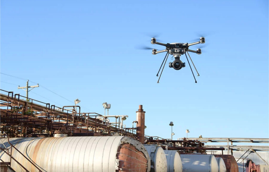 A SkyRanger-R-70 drone hovers over an industrial yard.