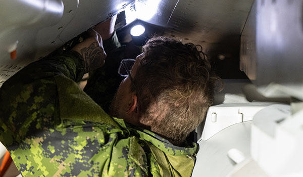 A Royal Canadian Air Force (RCAF) member changes a piece of equipment on a CF-188 Hornet from Air Task Force (ATF) Tarassis, deployed as part of Operation REASSURANCE, at Ämari Air Base, Estonia, on October 14, 2025.
